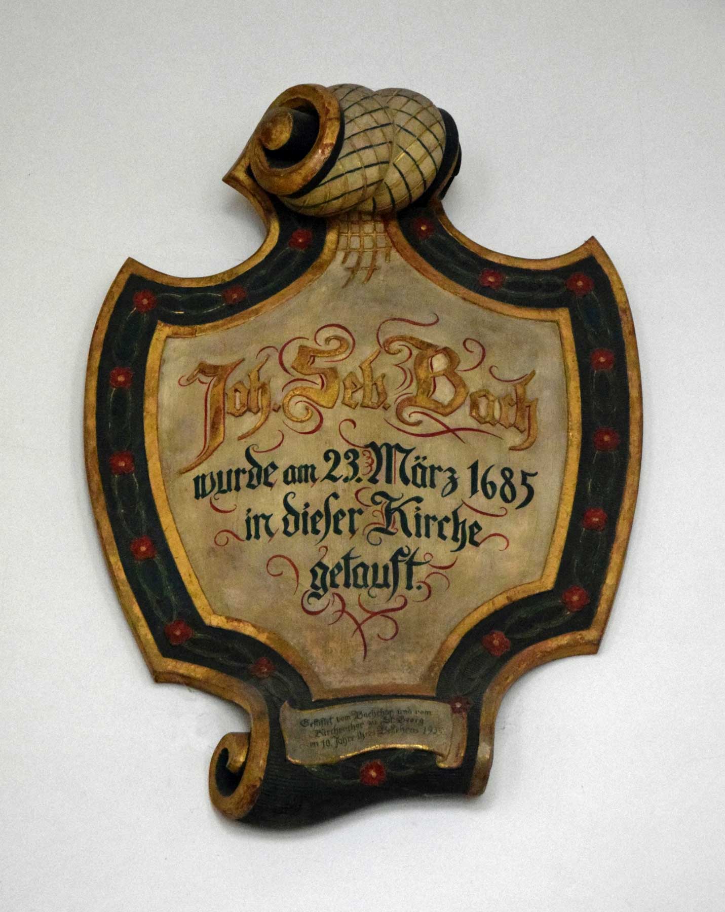 A wooden memorial plate above the entrance portal of the Georgenkirche in Eisenach, commemorating Bach's baptism according to the Julian calendar.